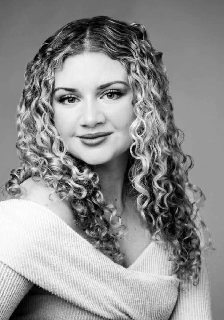 A woman with long hair and a white sweater.